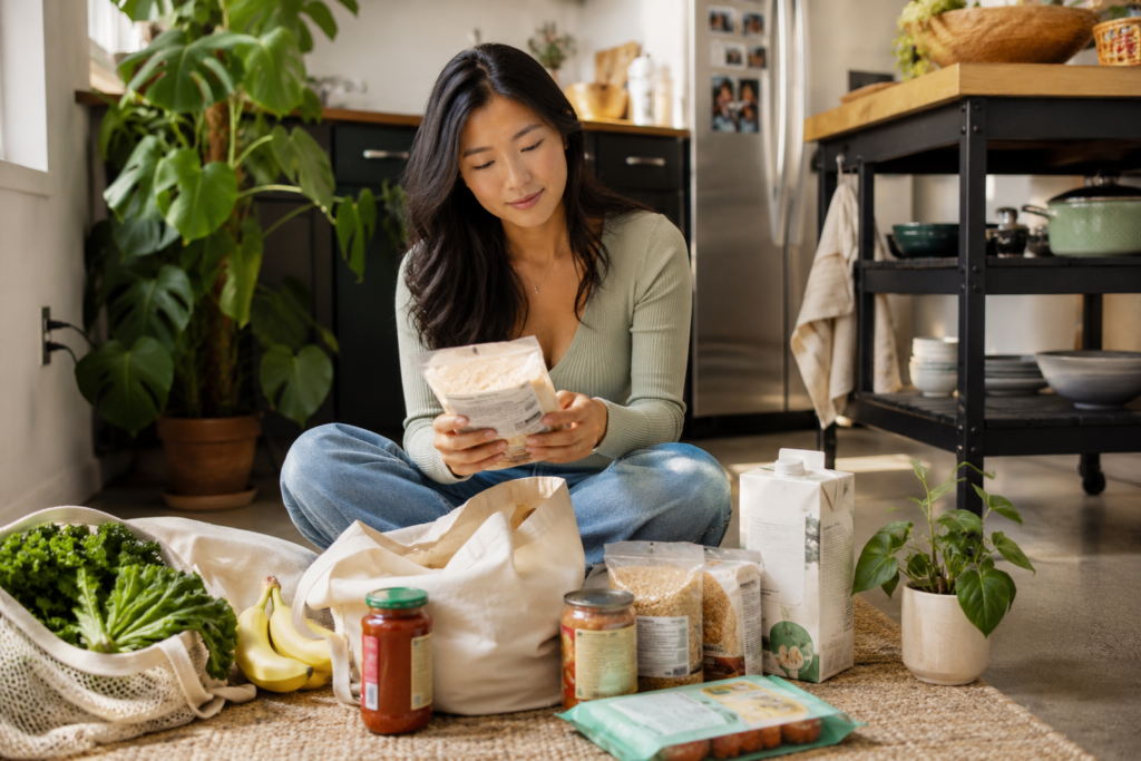 how-to-read-ingredient-lists Woman casually checking ingredient lists while unpacking groceries at home.