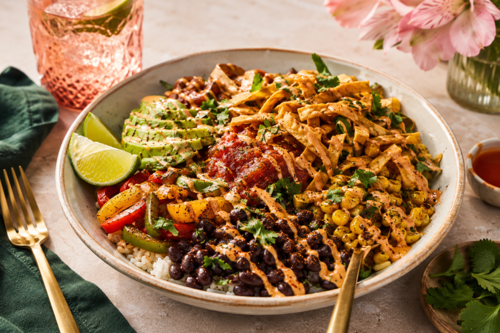 satisfying-plant-based-taco-bowl-cravings A satisfying plant-based taco bowl with beans, rice, avocado, salsa, peppers, and crunchy toppings for curbing meat cravings.