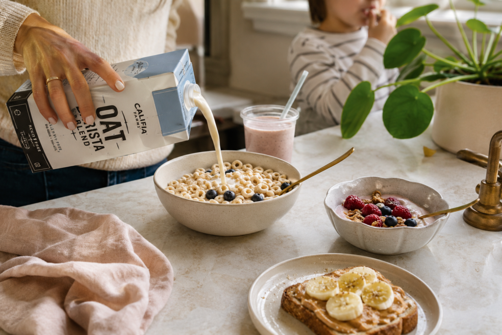 Plant-based breakfast swaps for kids with oat milk cereal, dairy-free yogurt, toast with peanut butter, fruit, and smoothie.