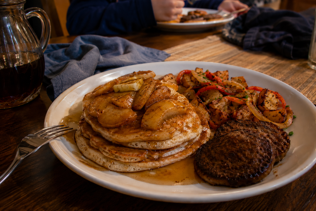Vegan apple-cinnamon pancakes with warm apples, crispy breakfast potatoes, and plant-based sausage for dinner.